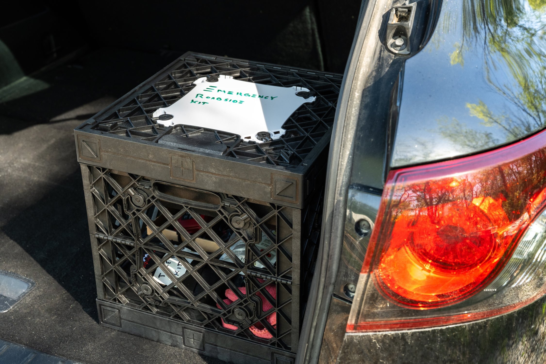 UbeCube&trade; emergency roadside kit stored in a vehicle trunk with a labeled Whiteboard MOD Panel on top.