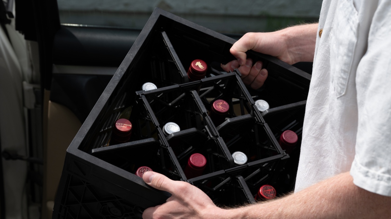 Portable CrateWine&trade; wine storage crate being carried in vehicle trunk for event transport.