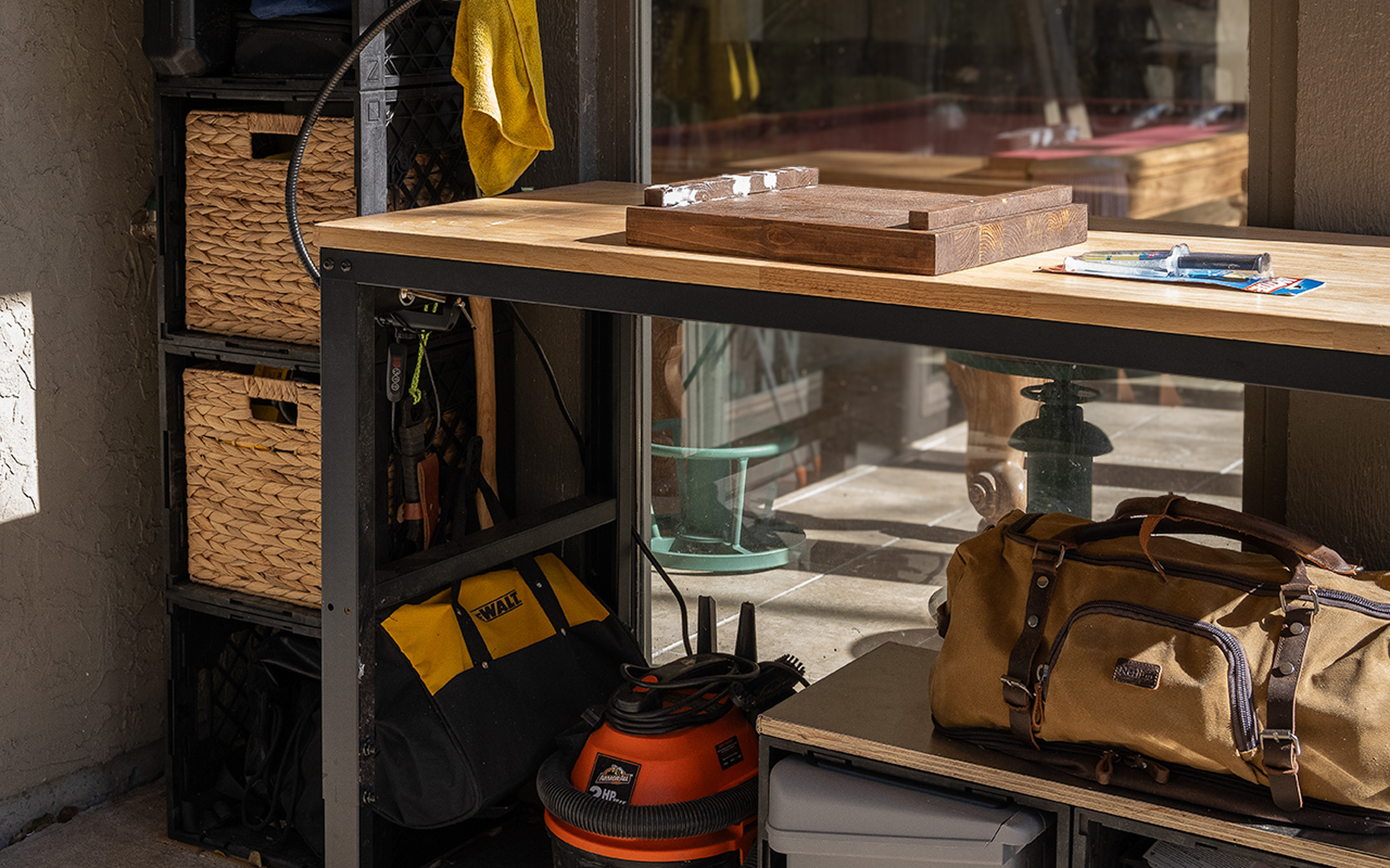 Compact hobby workbench paired with modular crate storage underneath and beside the table, organizing tools, bags, and supplies while maximizing usable space in a small home work area.
